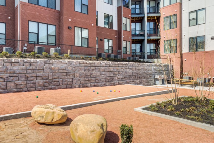 A bocce ball field located adjacent to the grill area, encircled by the charming apartment buildings within the Views of Music City community, in Nashville, TN.